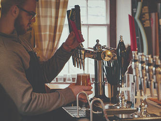 photograph of man pouring a majestic beer in a cosy pub